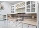 Charming wet bar featuring sleek countertops, wine rack, glass shelving, and stylish mosaic backsplash at 325 W Greyhound Pass, Carmel, IN 46032