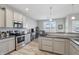Bright kitchen featuring stainless appliances, gray cabinets, and modern lighting at 3254 S Ansley Dr, New Palestine, IN 46163