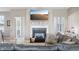 Bright living room featuring a fireplace, large TV, gray walls, and hardwood-style flooring at 3254 S Ansley Dr, New Palestine, IN 46163