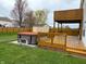 Backyard featuring a wooden deck, hot tub, storage shed, green grass, and surrounding wood fence at 373 Springfield Cir, Greenwood, IN 46143