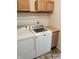 Functional laundry room area with wooden cabinets and a white washer and dryer set at 373 Springfield Cir, Greenwood, IN 46143