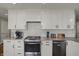 A beautifully renovated kitchen showcases white cabinets, stainless steel appliances, and a tiled backsplash at 3940 E 600 N, Columbus, IN 47203