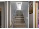 Carpeted staircase with a wooden railing leads upwards, and offers access to other levels of the home at 3940 E 600 N, Columbus, IN 47203