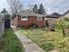 Brick house with a lawn featuring greenery, trees, and a walkway leading to a fenced area at 4151 Bowman Ave, Indianapolis, IN 46227