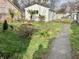 Backyard view featuring a white shed surrounded by a lawn, trees, and a concrete walkway at 4151 Bowman Ave, Indianapolis, IN 46227