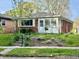 Charming brick home with a cozy sunroom, white trim, and a well-manicured front yard at 4151 Bowman Ave, Indianapolis, IN 46227