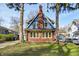 Beautiful two-story home with a red brick and blue exterior, complemented by mature trees at 420 N Irvington Ave, Indianapolis, IN 46219