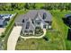 An elevated perspective captures the home's symmetrical design, complemented by vibrant green grass and meticulously arranged shrubbery at 5130 Melbourne Pl, Zionsville, IN 46077