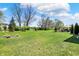 Lush green backyard featuring a firepit, landscaping, and open space at 5130 Melbourne Pl, Zionsville, IN 46077
