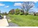 Spacious backyard with a large lawn, trees, and a glimpse of the patio, perfect for outdoor activities at 5130 Melbourne Pl, Zionsville, IN 46077