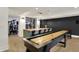 Entertaining basement space with a wet bar, shuffleboard table, and exercise equipment in the background at 5130 Melbourne Pl, Zionsville, IN 46077
