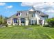 Beautiful two-story home boasts a well-manicured lawn, mature trees, and traditional architectural details at 5130 Melbourne Pl, Zionsville, IN 46077