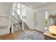 Grand foyer with wood floors, staircase, and large windows creates a bright, welcoming entrance at 5130 Melbourne Pl, Zionsville, IN 46077