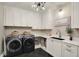 Modern laundry room with a washer, dryer, cabinets, countertop, and sink at 5130 Melbourne Pl, Zionsville, IN 46077
