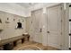 Welcoming mudroom featuring wainscoting walls, bench seating, and ample storage space with coat hooks at 5130 Melbourne Pl, Zionsville, IN 46077