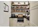 Walk-in pantry with custom shelving, stainless steel microwave, and ample storage space for all your essentials at 5130 Melbourne Pl, Zionsville, IN 46077
