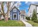 Charming blue two-story home featuring a welcoming front porch and a well-maintained lawn at 555 N Hamilton Ave, Indianapolis, IN 46201