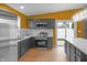 This kitchen features stainless steel appliances, quartz countertops, and an island with gray cabinetry at 555 N Hamilton Ave, Indianapolis, IN 46201