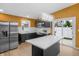 This kitchen features stainless steel appliances, an island with quartz countertops, and modern backsplash at 555 N Hamilton Ave, Indianapolis, IN 46201