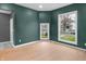 Bright living room with hardwood floors, large windows, and modern green walls at 555 N Hamilton Ave, Indianapolis, IN 46201