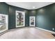 Stylish living room with large windows, hardwood floors, and modern green walls at 555 N Hamilton Ave, Indianapolis, IN 46201