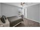 A well-lit bedroom with gray walls, neutral carpet, and a ceiling fan at 5788 Terracotta Trce, McCordsville, IN 46055