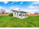 Lawn view of a home's fenced backyard with green grass, a covered patio, and white vinyl siding at 6036 Terrytown Pkwy, Indianapolis, IN 46254