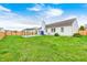Lawn view of a large fenced backyard featuring a covered patio area, and green grass at 6036 Terrytown Pkwy, Indianapolis, IN 46254