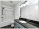 Bathroom features a tub, shower, and vanity with blue cabinets and a granite countertop at 6036 Terrytown Pkwy, Indianapolis, IN 46254