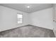 Bright bedroom features neutral walls, gray carpeting, and a window with natural light at 6036 Terrytown Pkwy, Indianapolis, IN 46254
