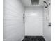 Modern walk-in shower with white subway tile and black mosaic tile flooring at 6036 Terrytown Pkwy, Indianapolis, IN 46254