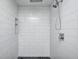Stylish shower featuring white subway tile, black mosaic tile flooring, and a rainfall shower head at 6036 Terrytown Pkwy, Indianapolis, IN 46254