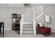 Finished basement with carpeted stairs, a dark metal shelf, and a red patterned chair with a lamp at 634 N Senate Ave, Indianapolis, IN 46202