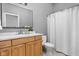 Bright bathroom with white countertops, modern sink, wood cabinets, and white tile floors at 634 N Senate Ave, Indianapolis, IN 46202