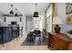 A modern dining area features a long table, stylish chairs, and a wooden cabinet with wine storage, bathed in natural light at 634 N Senate Ave, Indianapolis, IN 46202