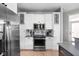 Elegant kitchen featuring white cabinetry, a stainless steel microwave, and a marble backsplash at 634 N Senate Ave, Indianapolis, IN 46202