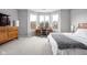 Serene primary bedroom with a cozy bay window, a work space, a wooden dresser and carpet floors at 634 N Senate Ave, Indianapolis, IN 46202