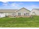 Well-maintained backyard with green lawn, brick foundation, and a patio area for outdoor relaxation at 639 Nuttal St, Westfield, IN 46074