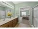 Well-lit bathroom with a double sink vanity, glass shower, and view into the bedroom at 639 Nuttal St, Westfield, IN 46074