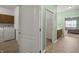 Hallway leads past laundry room and bathroom vanity to bedroom, enhancing the flow of this inviting floorplan at 639 Nuttal St, Westfield, IN 46074