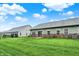 Large backyard with a well-maintained lawn, patio, and exterior view of multiple homes with brick accents at 661 Overcup St, Westfield, IN 46074