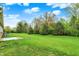 Lush backyard featuring a pristine lawn, patio and beautiful trees surrounding the property at 661 Overcup St, Westfield, IN 46074