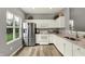 Modern kitchen with stainless steel fridge, white cabinets, and hardwood flooring at 661 Overcup St, Westfield, IN 46074