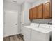 Laundry room featuring laminate flooring, a laundry tub, and a washer and dryer at 661 Overcup St, Westfield, IN 46074