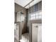 Modern bathroom featuring a glass shower with pebble floor, and gray tile walls, creating a spa-like atmosphere at 768 Trailside Dr, Carmel, IN 46032
