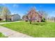 Expansive front yard with lush green grass complements this charming brick home at 7854 Crooked Meadows Dr, Indianapolis, IN 46268
