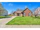 Well-maintained front lawn and mature trees enhance the curb appeal of this lovely home at 7854 Crooked Meadows Dr, Indianapolis, IN 46268