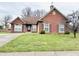 Charming brick home featuring a well-manicured lawn and a welcoming red front door at 7854 Crooked Meadows Dr, Indianapolis, IN 46268