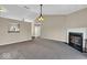 Spacious living room featuring a fireplace, plush carpeting, and modern lighting fixtures at 7854 Crooked Meadows Dr, Indianapolis, IN 46268