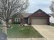 Charming single-story brick home featuring an attached garage and a blossoming tree in the front yard at 7916 Begonia Ct, Indianapolis, IN 46113